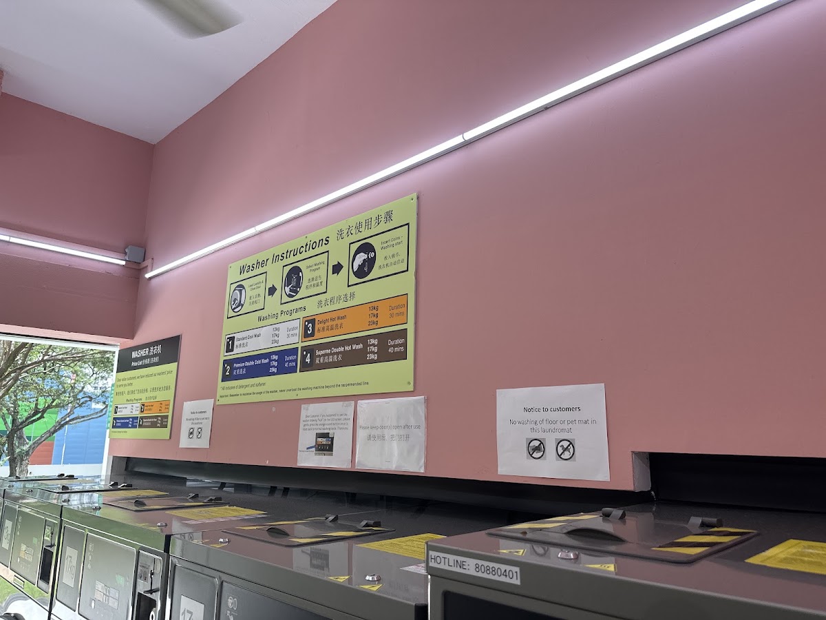 Washer instruction boards on the pink wall above the machine row